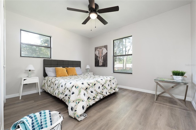 bedroom featuring ceiling fan, wood finished floors, and baseboards