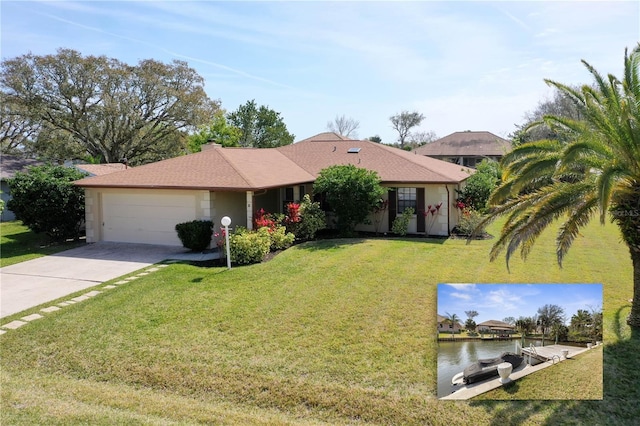 ranch-style house with an attached garage, a water view, concrete driveway, and a front yard