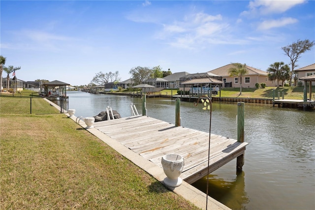 dock area with a residential view, a water view, a yard, and fence