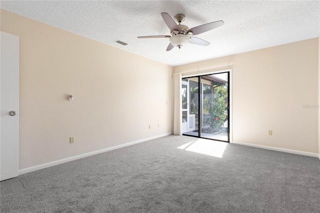 unfurnished room with a textured ceiling, carpet floors, visible vents, and baseboards