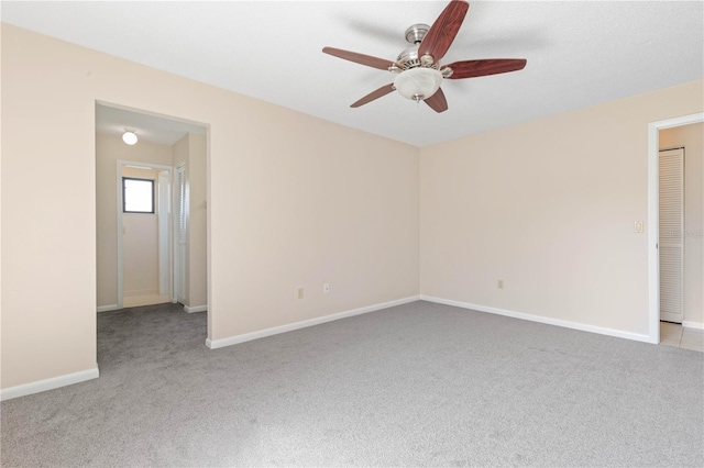 unfurnished room with carpet, baseboards, and a ceiling fan