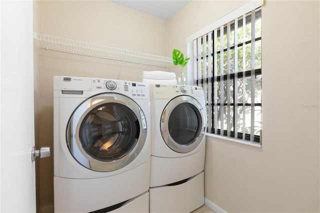 clothes washing area with laundry area, separate washer and dryer, and a wealth of natural light