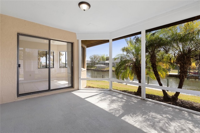 unfurnished sunroom featuring a water view