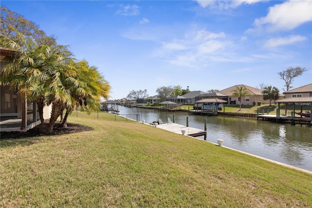 view of yard with a water view, a residential view, and a dock