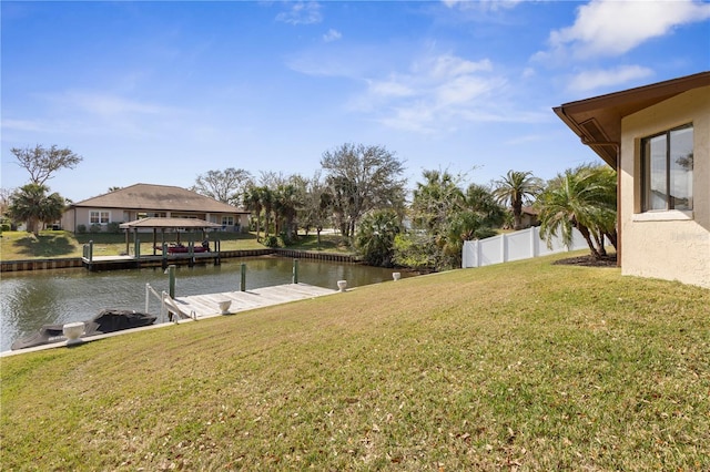 view of yard featuring a water view, a dock, and fence