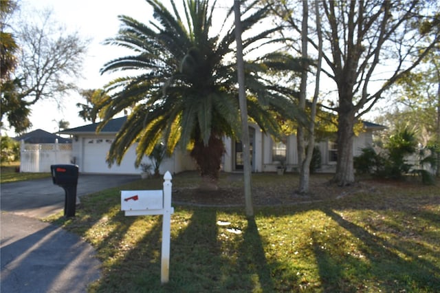 obstructed view of property featuring a front yard, driveway, and an attached garage