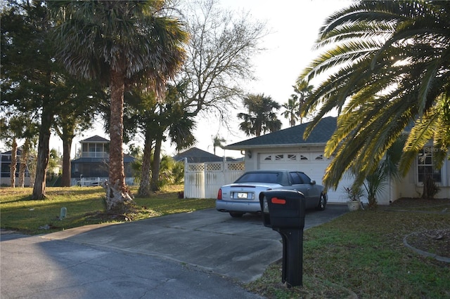 view of front of home featuring a front yard, concrete driveway, and an attached garage