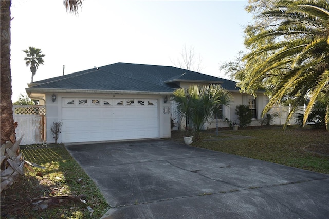 single story home with driveway, fence, an attached garage, and stucco siding