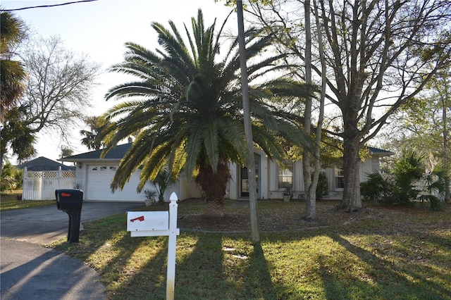 view of front of property with driveway, a garage, and fence