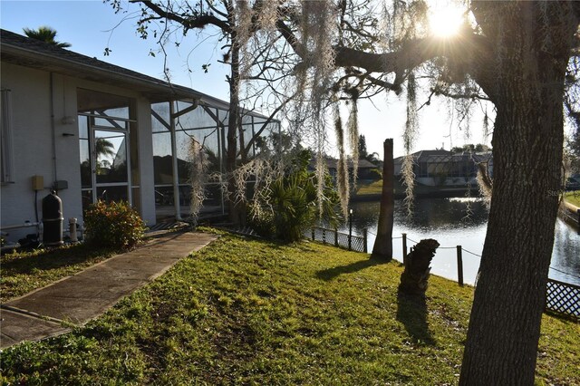 view of yard featuring glass enclosure and a water view