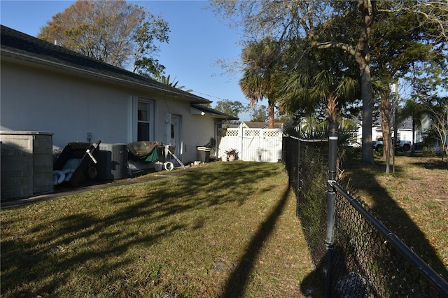 view of yard featuring fence and central air condition unit