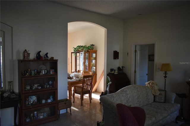 tiled living room featuring arched walkways