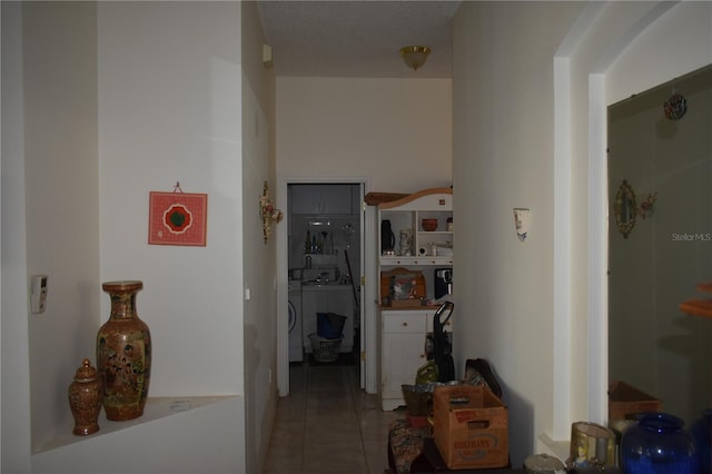 corridor with washer / clothes dryer and tile patterned flooring