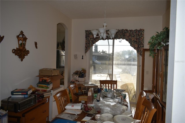 dining space with arched walkways and an inviting chandelier