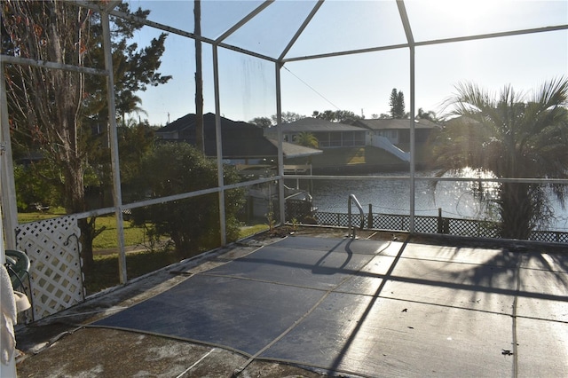 exterior space with glass enclosure and a water view