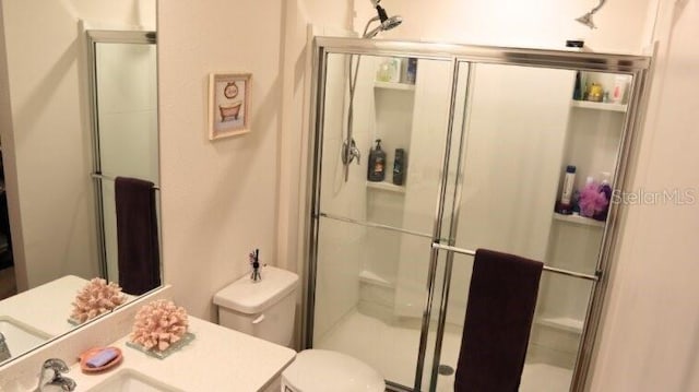 bathroom with a stall shower, a sink, and toilet