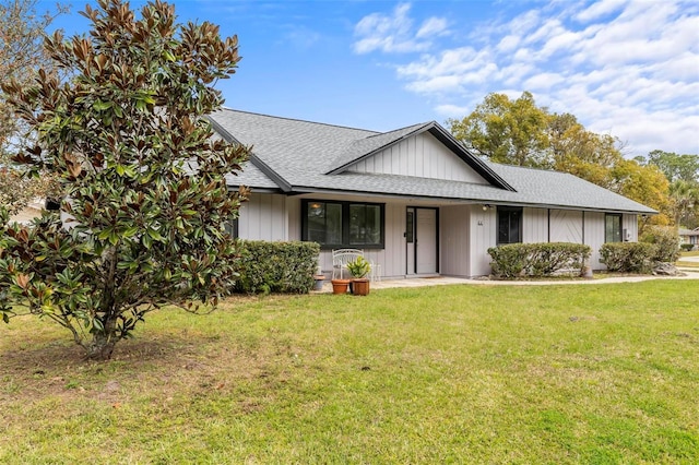 ranch-style house featuring covered porch, a front lawn, and roof with shingles