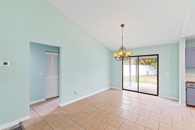 empty room featuring light tile patterned floors, a textured ceiling, lofted ceiling, a notable chandelier, and baseboards