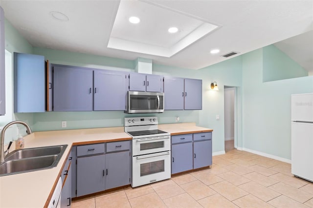 kitchen featuring white appliances, visible vents, a raised ceiling, light countertops, and a sink