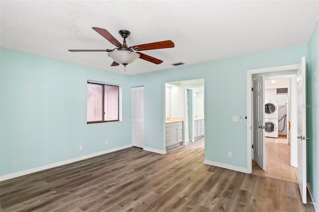 unfurnished bedroom with washer / clothes dryer, visible vents, baseboards, and wood finished floors