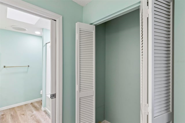 bathroom featuring wood finished floors, toilet, and baseboards