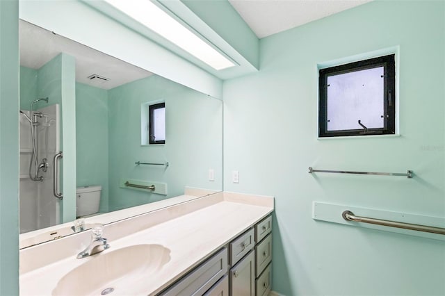 full bath featuring visible vents, a shower, vanity, and toilet