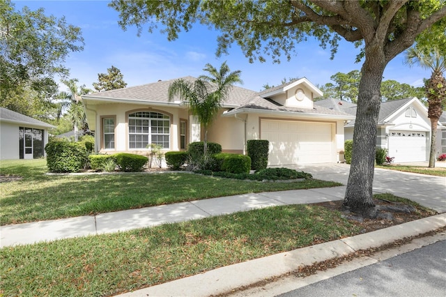 ranch-style home featuring a front yard, concrete driveway, and stucco siding