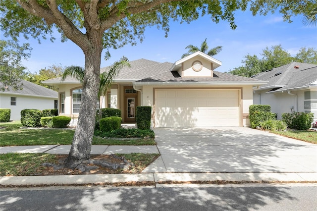 ranch-style home with driveway, a shingled roof, an attached garage, and stucco siding