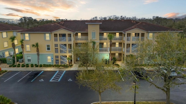 view of building exterior with central air condition unit and uncovered parking