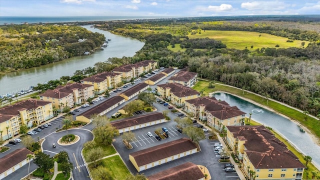 bird's eye view with a water view and a wooded view