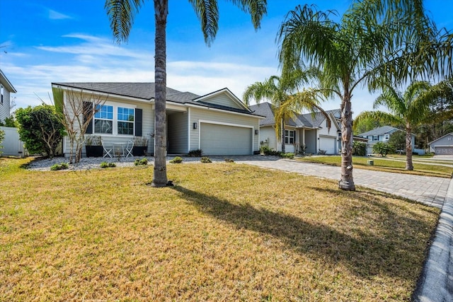 single story home featuring a front lawn, decorative driveway, and an attached garage