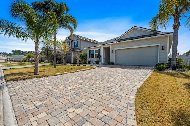 view of front of property featuring an attached garage, decorative driveway, and a front yard