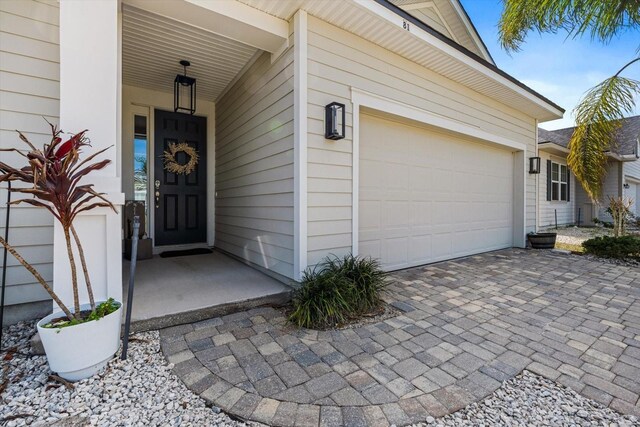 property entrance featuring a garage and decorative driveway