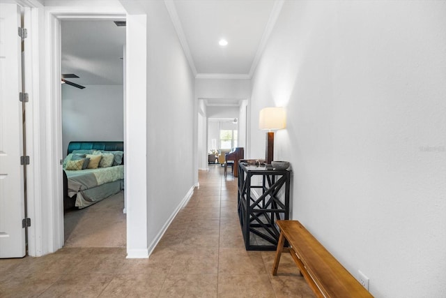 hallway featuring ornamental molding, light tile patterned flooring, and baseboards