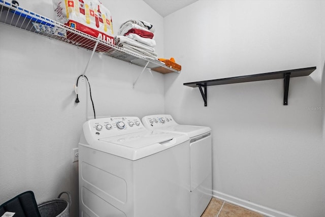 clothes washing area featuring laundry area, independent washer and dryer, light tile patterned flooring, and baseboards