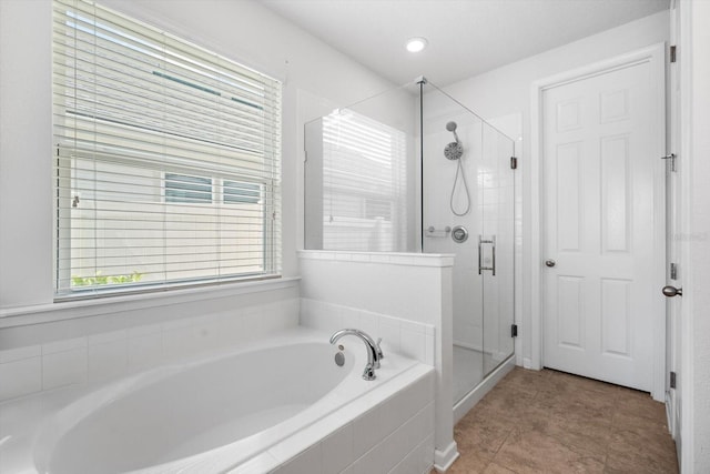 bathroom with a garden tub, a shower stall, and tile patterned floors