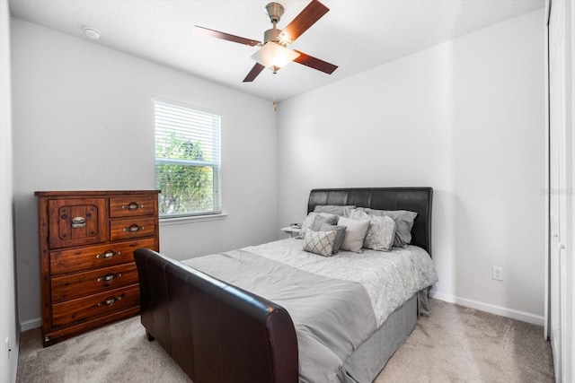 bedroom with baseboards, a ceiling fan, and light colored carpet