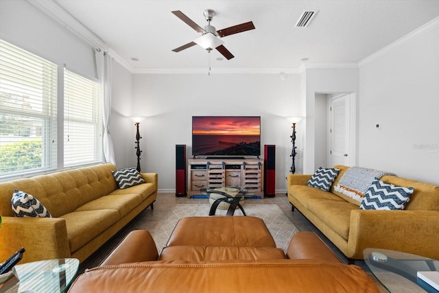 living room with ceiling fan, visible vents, baseboards, and ornamental molding