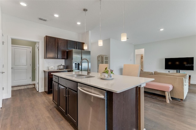 kitchen with dark wood-style flooring, visible vents, appliances with stainless steel finishes, open floor plan, and a sink