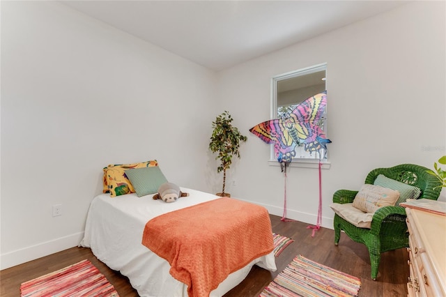 bedroom with wood finished floors and baseboards