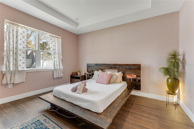 bedroom with baseboards and wood finished floors