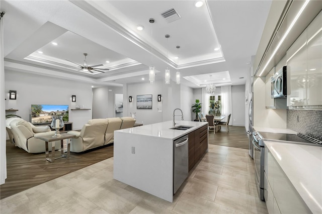 kitchen featuring visible vents, appliances with stainless steel finishes, a raised ceiling, and a sink