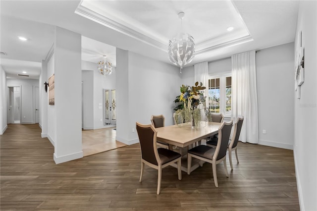 dining room with a raised ceiling, baseboards, a notable chandelier, and dark wood-style flooring