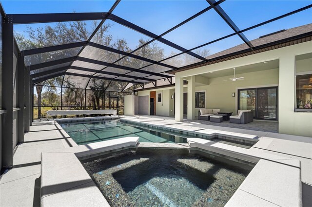 view of pool featuring a pool with connected hot tub, an outdoor hangout area, glass enclosure, a patio area, and ceiling fan