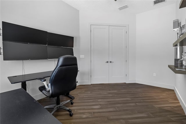 office area with visible vents, baseboards, and wood finished floors