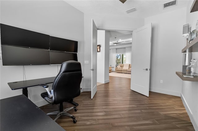 home office featuring a ceiling fan, visible vents, and wood finished floors