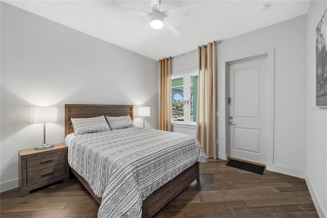 bedroom featuring dark wood-style floors, ceiling fan, and baseboards