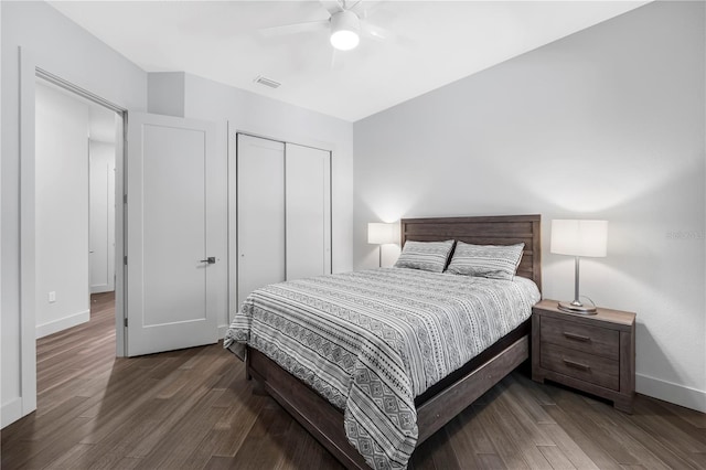 bedroom with a closet, visible vents, baseboards, and wood finished floors