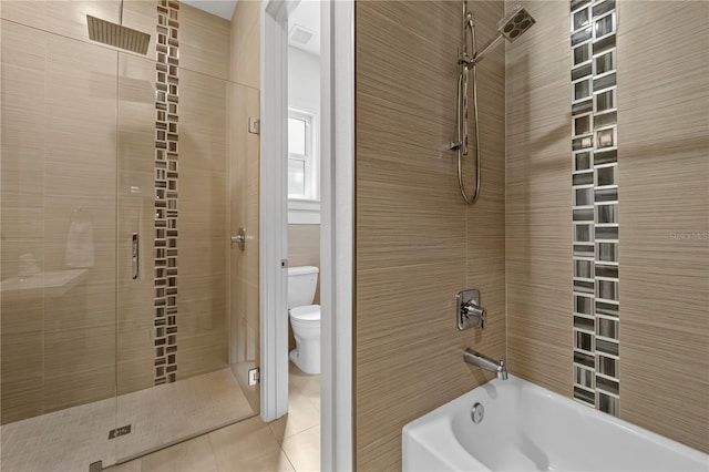 bathroom featuring toilet, tiled shower / bath, and tile patterned floors