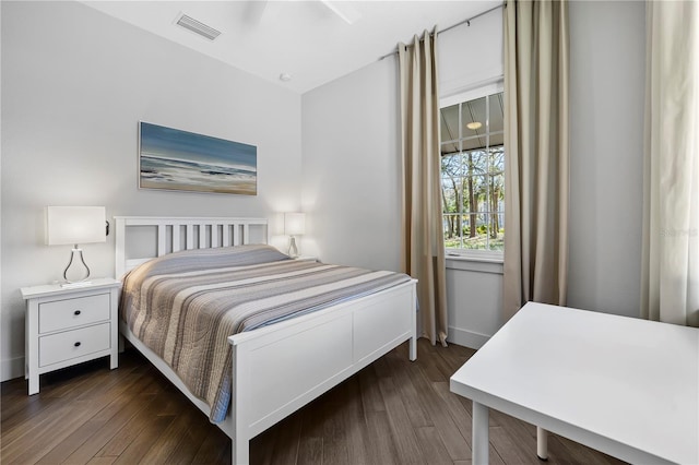 bedroom with baseboards, visible vents, and dark wood-type flooring